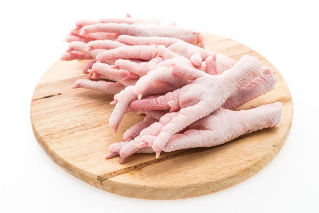 Raw chicken feet on a wooden platter